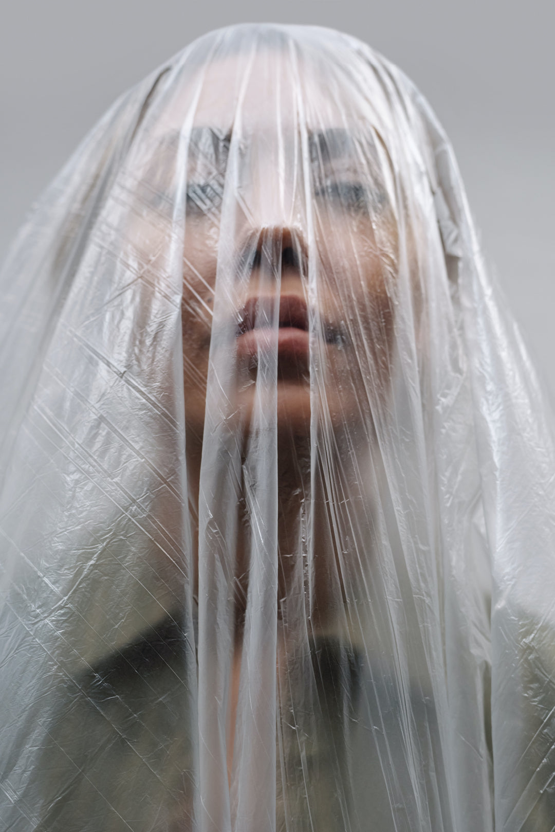 Woman with plastic packaging over her head - An image to symbolise the ever-growing reliance on plastic packaging in the modern world.