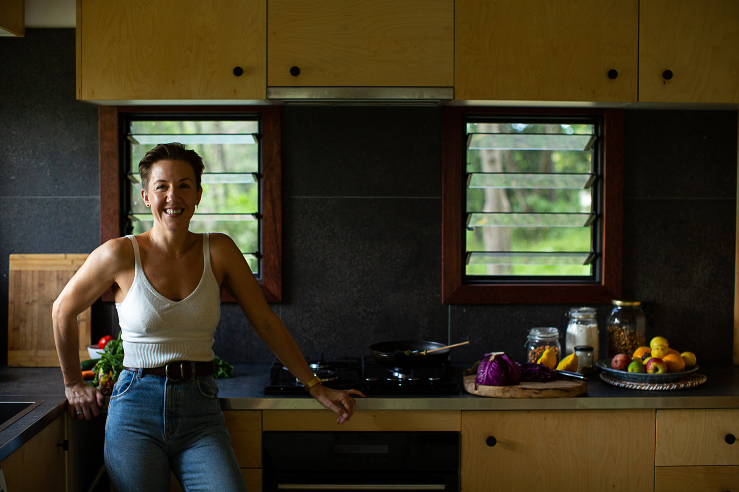 Jadine from Alchemical Nutrition in her workplace, the kitchen with various nutritionally dense foods on the bench